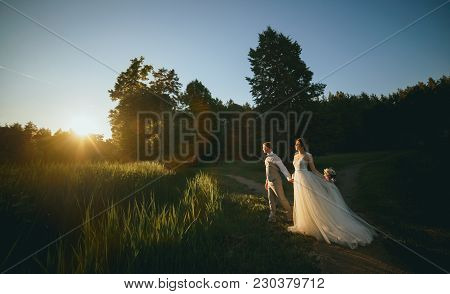The Bride And Groom At Sunset On A Dark Background