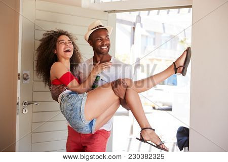 Man Carries Woman Over Threshold Of Honeymoon Rental