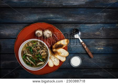 Fresh Mushroom Soup With Green Onion Sour Cream And Bread Crisps. On A Ceramic Plate. Colored Wooden