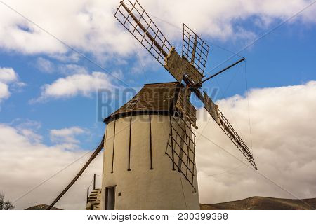Spanish Windmill Made Of Stone With Blue Sky And Dark Clouds