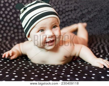 Portgait Of Little Nacked Baby Girl On Black In Peas Background.