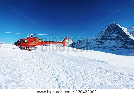 Mannlichen, Switzerland - December 31, 2013: Red Helicopter At Swiss Alpine Mountain Mannlichen In W
