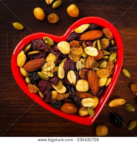 Energy Blend Trail Mix With Nuts And Dried Fruits In Heart Shaped Bowl. Selective Focus.