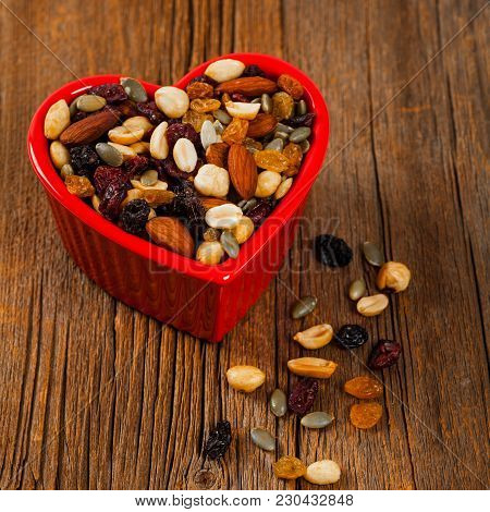 Energy Blend Trail Mix With Nuts And Dried Fruits In Heart Shaped Bowl. Selective Focus.