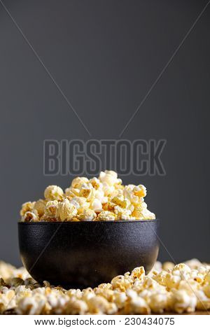 Popcorn In A Black Refined Ceramic Bowl And Around It.