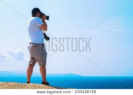Man With Camera Taking Photos Of The Mediterranian Sea In Capo Testa, Santa Teresa Gallura, Sardinia