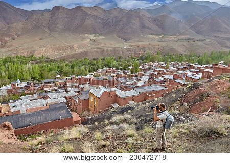 Abyaneh Village,  Isfahan Province, Iran - April 26, 2017: A Lone Hiker Photographs The Rooftops Of 