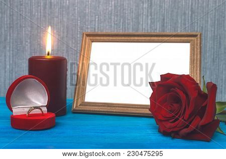 Wedding Ring In A Gift Present Box And Empty Photo Frame Of A Loved One Copy Space And Red Rose Flow