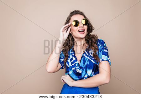 Smiling Summer Woman With Sunglasses Over Bright Background. Studio Shot, Copy Space