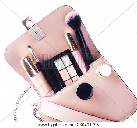 flat lay of pink leather woman bag open out with cosmetics, acce