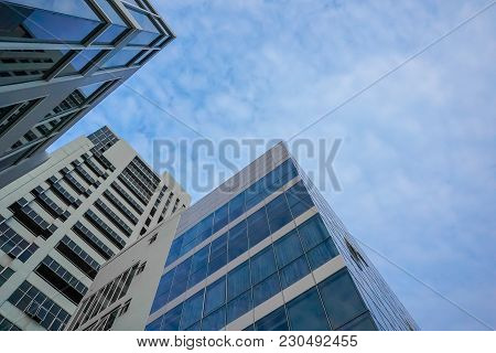 Bottom View Of Modern Skyscrapers In Business District Against Blue Sky
