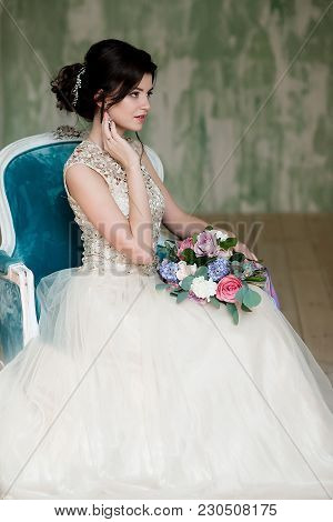 Half Length Portrait Of Brunette Smiling Woman Dressed In Sleeveless Light Evening Dress.