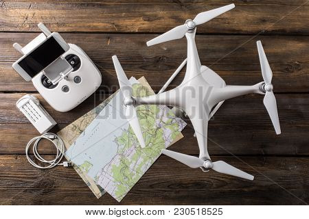 Drone equipment. Remote control, drone, screw, map on gray background. Top view