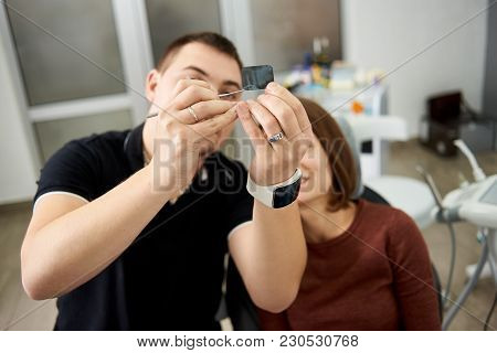 Dentist Shows The Patient The Features Of The X-ray Of The Teeth Shot In A Modern Dental Office. Foc