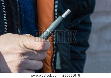 Iqos Heat-not-burn Tobacco Product Technology. Man Holding E-cigarette In His Hand Before Smoking.