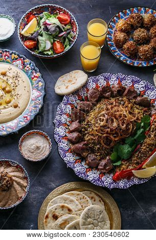 Middle Eastern Or Arabic Dishes And Assorted Meze On A Dark Background. Meat Kebab, Falafel, Baba Gh