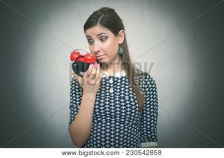 Overslept Shocked Woman Holding In Hand A Red Alarm Clock. Be Late At Work Or School. Oversleep. Lat