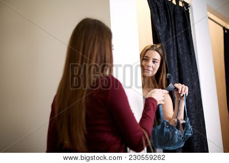 Beautiful Young Woman Asking For A Friends Opinion In The Fitting Room Of Lingerie Store. Female Tri