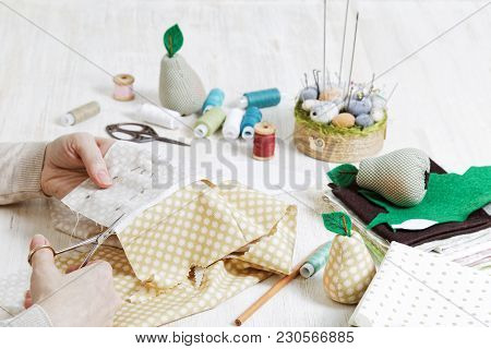Hands Of The Needlewoman Hold Scissors And Cut Out A Piece Of Pattern For A Handmade Toy