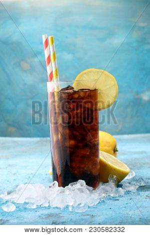 Softdrink With Ice Cubes, Lemon And Straw In Glass.
