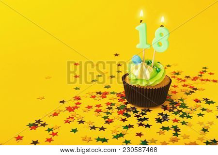 18th Birthday Cupcake With Candle And Sprinkles On Yellow Background. Card Mockup, Copy Space. Birth