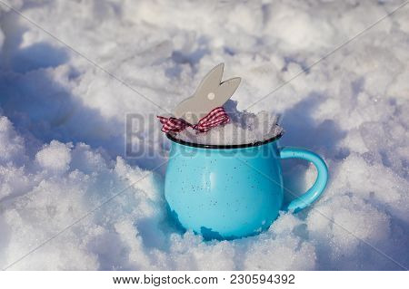 Wooden Polka Dot Grey Rabbit In A Blue Cup On Snow Background, Easter Postcard Concept, Toned