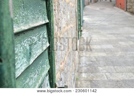 Part Of Wooden Blinds With An Alley Paved With Stones