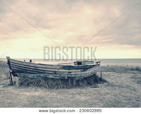 Wrecked Wooden Fisher Boat. Broken Abandoned Boat In Sand Of Sea Bay. Wheatered Wood And Rusty Meata