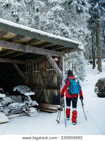 Mummelsee, Germany - Feb 18, 2018: Male Skier Near The Garage Of The Modern Snow Plough Groomer In M