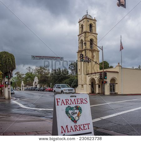 Downtown Ojai Tower Closest To Winter Rain Clouds As Sign Points Way To Local Farmers Market.  Shot 