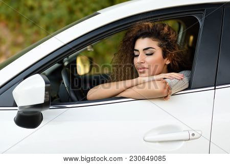 Young Arabic Woman Inside A White Car With Eyes Closed