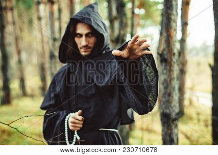 The Black Monk Pointing His Finger In The Woods