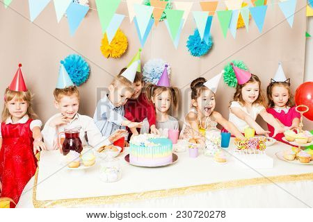 Kids Are Celebrating Birthday. Children Near The Table, Friends Are Exciting In The Hours Of Sweet P