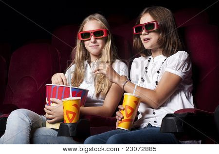 zwei schöne Mädchen, die einen Film im Kino