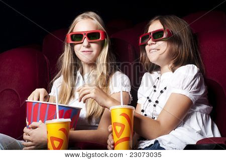 zwei schöne Mädchen, die einen Film im Kino