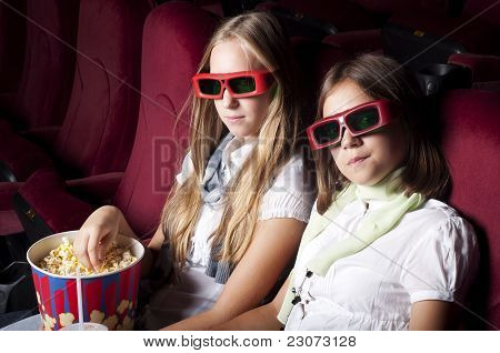 Zwei schöne Mädchen, die einen Film im Kino
