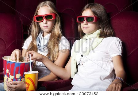 Zwei schöne Mädchen, die einen Film im Kino
