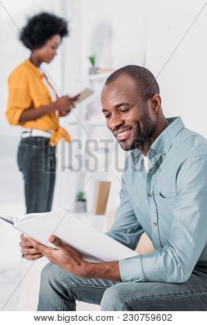 African American Couple Reading Books At Home