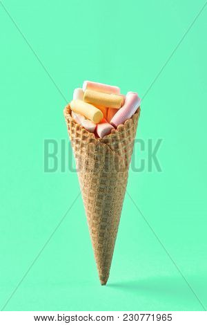 Pink And Yellow Marshmallows In Waffle Cone On Light Green Background. Top View, Flat Lay. Free Spac