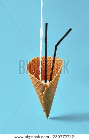 Ice Cream Cone With Black Drinking Straws And Milk Shake On Bright Blue Background. Minimal Concept 