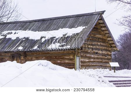 Wooden Restored Barn. Built In The 18th Century. A Log Wall And A Corner Joint Of Logs. Interesting 