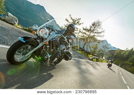 Motorcycle drivers riding in Alpine highway on famous Hochalpenstrasse, Austria, central Europe.