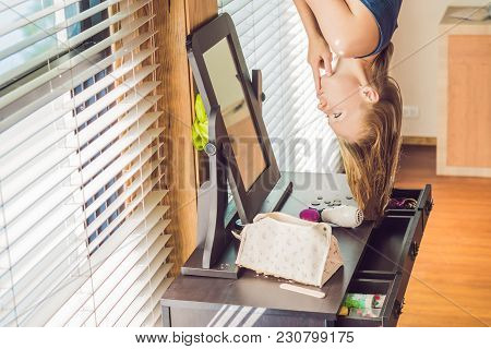 Woman Upside Down In The Bedroom Above The Dressing Table.
