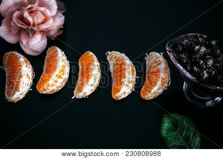 Vitamin C. 5 Fresh Mandarin Slices And Frozen Black Currant In Glass Dish On A Black Background Deco