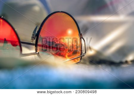 Red Stylish Woman Sunglasses With Reflection Of Summer Beach With Black Sand, Sundown And Tyrrhenian