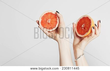 Close Up Hand Holding A Sliced Fresh Orange Fruit. Isolated On A Background With Copy Space For Text