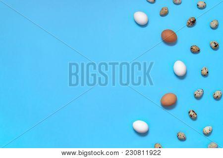 Border Of White, Brown And Quial Eggs On Blue Background, Copy Space. Healthy Food Concept. Top View