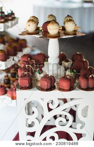 Candybar In A Restaurant. Decorated White Table Fool Of Sweet Pastry. Wedding Sweets.