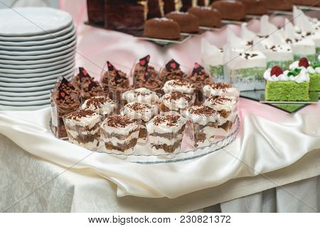 Candybar In A Restaurant. Decorated White Table Fool Of Sweet Pastry. Wedding Sweets.