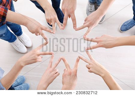 Young people putting hands together as symbol of unity